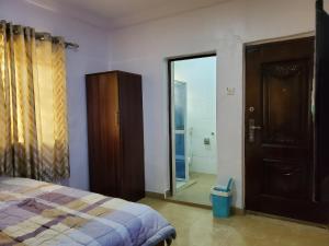 a bedroom with a bed and a sliding glass door at TSOLID HOMES ( SHORTLET & APARTMENT) in Ibadan