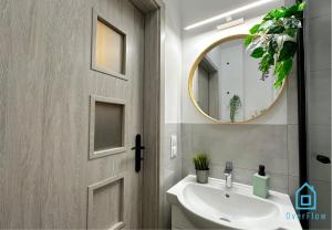 een badkamer met een wastafel en een spiegel bij Piggy Room in Gdańsk