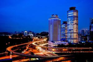 um horizonte da cidade com dois arranha-céus altos à noite em Wyndham Grand Bangsar Kuala Lumpur em Kuala Lumpur