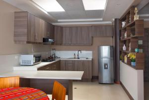 uma cozinha com armários de madeira e um frigorífico de aço inoxidável em TEYFA Hospedaje - Edificio em Atuntaqui