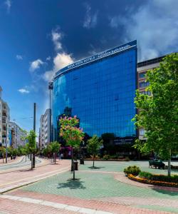 a large glass building with a tree in front of it at Nova Vista Centrum Hotel Eskisehir, a Member of Radisson Individuals in Eskisehir