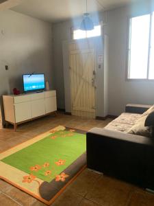 a living room with a couch and a television and a door at Hostel 858 in Pelotas