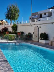 una piscina de agua azul frente a un edificio en Apartment with sea view close to dunes of playa del ingles en San Bartolomé