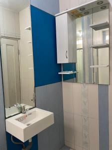 W łazience znajduje się umywalka i lustro. w obiekcie The 8 House – Surabaya City Center w mieście Surabaja