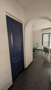 un couloir vide avec une porte bleue et des chaises dans l'établissement Loft ITSON: Comodidad + Asador, à Ciudad Obregón