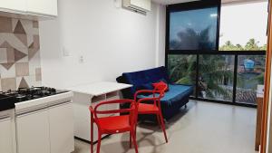 una cucina con due sedie rosse e un divano blu di Maraca Beach Residence 1 apartamento 401 a Porto De Galinhas