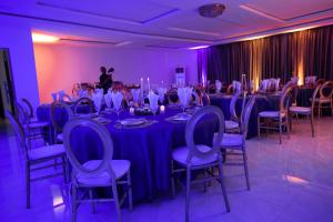 a room with long tables and chairs with purple lighting at ED&DRE Luxuria Hotel in Ibadan