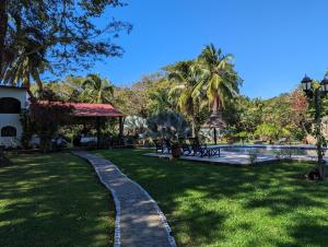 un jardín con piscina y palmeras en Paraiso Cocodrilo lodge - spirit of nature, en Sámara