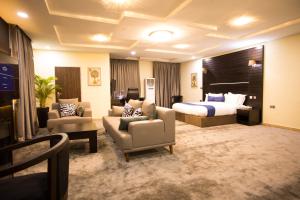 a hotel room with a bed and a bed and chairs at ED&DRE Luxuria Hotel in Ibadan