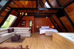 - une chambre avec un lit et un canapé dans l'établissement Glamping Guaytambos Lodge, à Patate