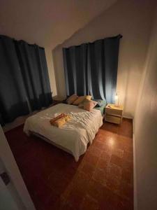 a bedroom with a bed and a table with a lamp at Casa Escaleras in Rincon