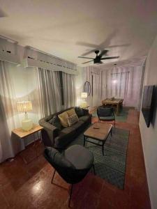 uma sala de estar com um sofá e uma ventoinha de tecto em Casa Escaleras em Rincon