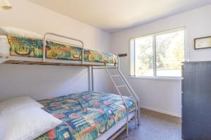 a bedroom with two bunk beds and a window at Kangaroo Cabin in Berrara