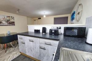 een keuken met een aanrecht met een magnetron bij Modern 2 Bed Apartment - Sleeps up to 5 - Coventry - Business and Leisure Stays in Coventry