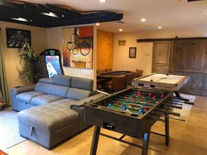 ein Wohnzimmer mit einem Sofa und einem Billardtisch in der Unterkunft Warm Sands Villa-Moving River/Island in Palm Springs