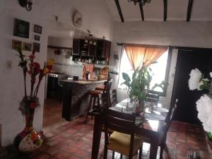 a living room with a table and a kitchen with a stove at Villa Rita in Tibasosa