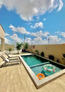 a swimming pool in the middle of a backyard at Casa Encanto das Dunas in Santo Amaro