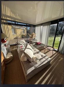 a living room with a couch and a large window at maison tout confort in Saint-Vivien-de-Médoc