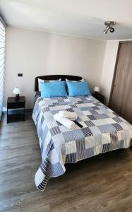 1 dormitorio con 1 cama grande con almohadas azules en Hermoso Depto En Casco Historico, en Santiago