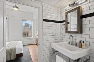 a white bathroom with a sink and a mirror at The Maverick, powered by Placemakr in San Antonio