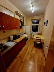 a kitchen with wooden cabinets and a table with a yellow counter top at Kaunas Center Apartment in Kaunas