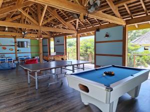 uma sala com duas mesas de pingue-pongue em Beach House Lodge 