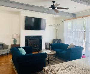 uma sala de estar com dois sofás azuis e uma lareira em The Gardens of Barons Creek Unit B em Fredericksburg