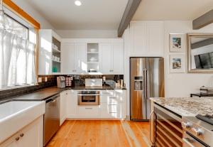 uma cozinha com armários brancos e um frigorífico de aço inoxidável em The Gardens of Barons Creek Unit B em Fredericksburg