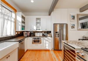 Una cocina con gabinetes blancos y un refrigerador de acero inoxidable. en The Gardens of Barons Creek Unit B, en Fredericksburg