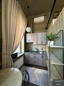 a small kitchen with a table and a sink at Apart hotel на Франка in Chernivtsi