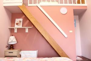 富里鄉的住宿－低調民宿，一间卧室设有粉红色的墙壁和楼梯
