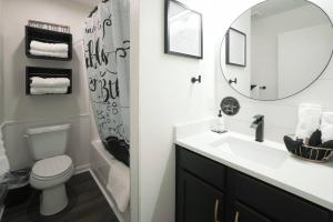 a bathroom with a sink and a toilet and a mirror at Ashley's Luxurious Snuggery! in Branson