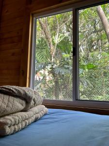 a bed in a room with a large window at Glamping Cabanas do Estaleiro in Balneário Camboriú +14 photos