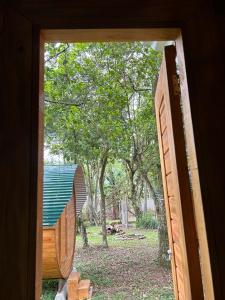 uma porta aberta para um quintal com uma árvore em Glamping Cabanas do Estaleiro em Balneário Camboriú