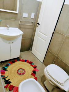 a bathroom with a toilet and a sink and a rug at Amplio dúplex en Lomas con cochera in Lomas de Zamora