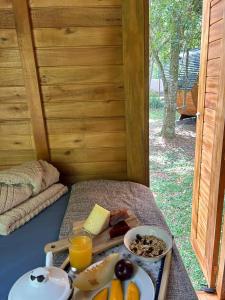 a table with a tray of food and orange juice at Glamping Cabanas do Estaleiro in Balneário Camboriú