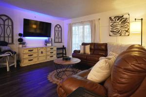 sala de estar con sofá de cuero y TV en Ashley's Luxurious Snuggery!, en Branson