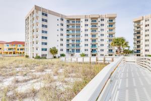 a walkway in front of a large apartment building at Pensacola Beach Condo with Patio and Access to Beach! in Pensacola Beach