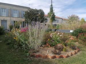 a garden in front of a building with flowers at Chez Mado in Thénac