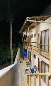 a balcony of a building with chairs and a palm tree at Gostoso Maresia Flats in São Miguel do Gostoso