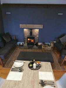 a living room with a table and a fireplace at Riverside Cottage B&B in Lynmouth