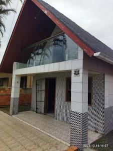 ein Haus mit einem großen Fenster an der Seite in der Unterkunft Cabana da barra in Içara