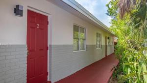 eine rote Tür an der Seite eines Gebäudes in der Unterkunft Crocodhouse ,parking ,free coffee in Fort Lauderdale