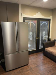 a stainless steel refrigerator in a living room with stained glass windows at Saratoga Family Spa in Ballston Spa