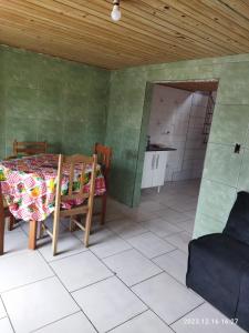 Zimmer mit einem Tisch und Stühlen sowie einer Küche in der Unterkunft Cabana da barra in Içara