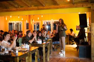 a woman standing on a stage in front of a crowd at Big Hostel in El Bolsón
