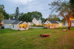 un groupe de maisons dans une cour avec un banc dans l'établissement Bar Harbor Cottages & Suites, à Bar Harbor 133 autres photos