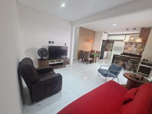 een woonkamer met een bank en een tv bij Casa Mar Aruana in Aracaju