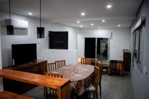 a dining room with a table and chairs and a television at un sueño para viajar in Ciudad Lujan de Cuyo