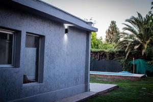 una casa con una ventana junto a un patio en un sueño para viajar en Luján de Cuyo